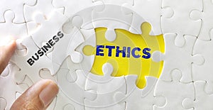 Close up piece of white jigsaw puzzle with word of Business Ethics , concept of business core value and moral