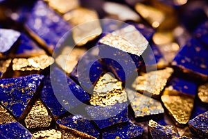 Close-up of pieces of semi-precious stones lazurite in deep blue color with gold splashes.