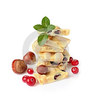 Close-up pieces of white chocolate bar with whole hazelnuts and cranberry