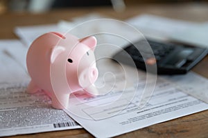 Close up of piggy bank with financial documents on table