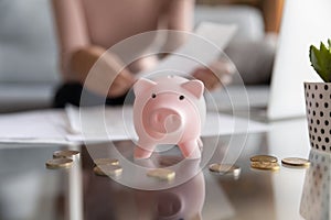 Close up of piggy bank on table with coins