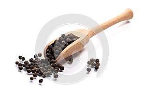 Close-up of pile of Black pepper seeds spice in a wooden spoon o