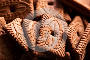 A close up of a pile of brown cookies called speculaas or speculoos in Belgium or the Netherlands. The spiced biscuit is very