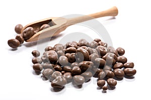 Close-up of pile dried, raw, chocolate raisins in a wooden spoon