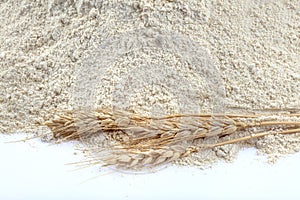 Close-up of a pile of flour and ears of wheat after sifting. Flour concept, material photo