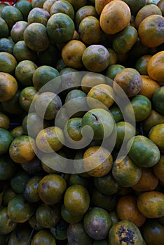 Close up of a pile of fresh local citrus fruits in a fruit basket in a traditional fruit shop for sale