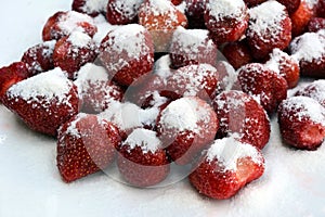 Close-up of a pile of juicy strawberries sprinkled with sugar on top. Top view, macro photography