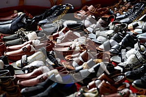 Close-up of a pile of leather shoes for sale at a market stall