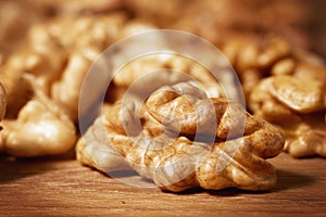 Close up of a pile of peeled walnut kernels on a wooden background. Macro photography