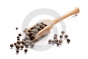 Close-up of pile of Pimento, Bahar seeds spice in a wooden spoon