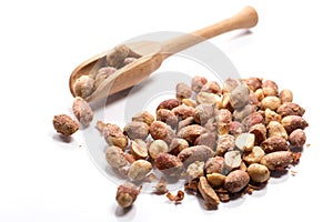 Close-up of pile of roasted, salted peanuts in a wooden spoon on