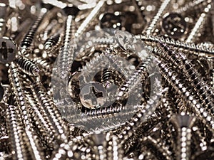 Close up pile of silver threaded steel screws