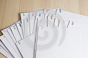 Close up pile of unfinished homework stacked in archive with colorful paper clips