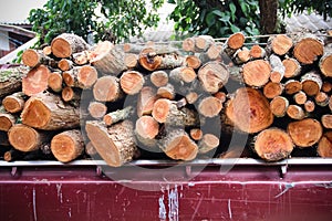 Close up piled of wood logs overlap in old red pickup truck , Transportation background