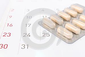 Close up pill with date of calendar background, health care and