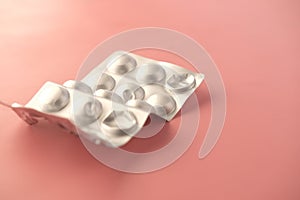 Close up of pills of blister pack on a pink background