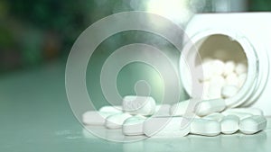 Close up of pills or caplets spinning on a table shot from above