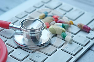 Close up of pills, stethoscope on keyboard