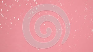 In the close up on a pink background is a flow of water that is directed somewhere, blurring the image. Demonstration of