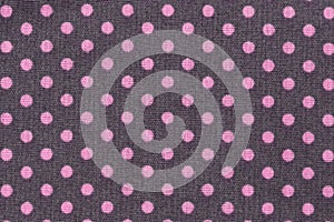 Pink dots over purple polka dot fabric background and texture.