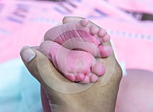 Close up pink feet of little baby in postpartum care unit with her mother, so cute.