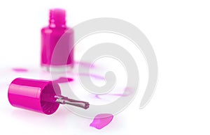 Close up of the pink nail polish bottle and drop on white background