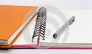 Close-up of pink, orange open note book and pen