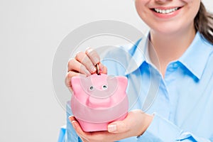 Close-up of a pink pig piggy bank in the hands of an economical