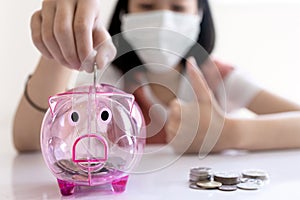 Close up of pink piggy bank,Concept of frugal,thrifty and economical, good saver, asian child girl put coin into piggy bank,saving