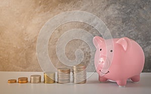 Close-up of pink piggy bank smile with coins stack stair step up growing growth saving money. concept Business Finance