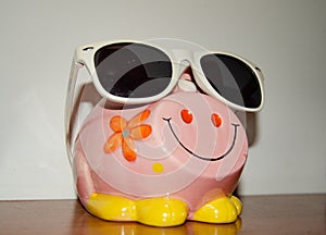 Close up of pink piggy bank with sun glasses