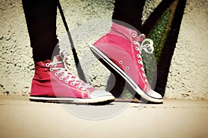 Close up of pink sneakers worn by a teenager.