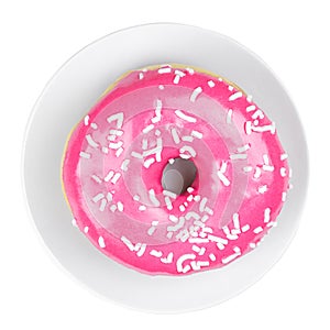 Close-up of pink strawberry donut decorated with sugar topping on a white plate isolated on white background. Top view