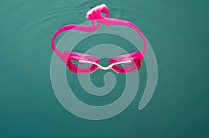 Close-up of  pink  swim goggles in  water.