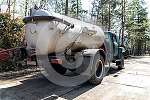 Close-up pipe hose of sewage truck car engine emptying home sewerage tank. Septic cleaning vacuum service and