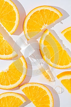 close up of pipette with pouring liquid serum and shadows on oranges background. Trendy cosmetics shot with hard shadows