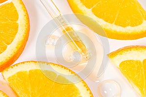 close up of pipette with pouring liquid serum with vitamin C and shadows on white background. Trendy cosmetics shot