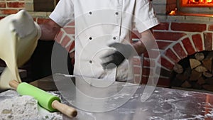 Close up of Pizza chef hands tossing pizza dough in the air in a traditional pizzeria kitchen