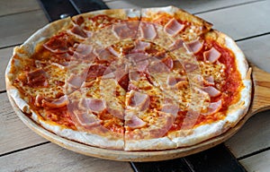 Close-up pizza ham cheese with tomato sources on wooden tray