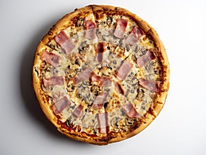 Close-up pizza with ham and mushrooms on a white background. A traditional Italian dish. A delicious and unhealthy dish. Top view