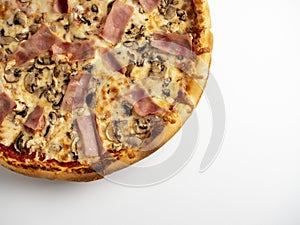 Close-up pizza with ham and mushrooms on a white background. A traditional Italian dish. A delicious and unhealthy dish. Top view