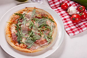 Close up of Pizza with prosciutto parma ham and  arugula salad rocket. Vegetables