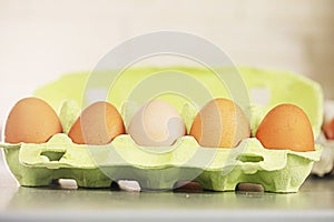 close-up of plain fresh brown eggs in a light green container. Preparation for the holiday