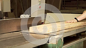 Close-up of a planer at a furniture factory. Worker planing a board in a workshop