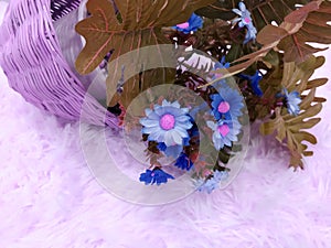 Close-up of plastic flowers on soft carpet.