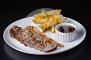 Close-up of a plate of food, containing a piece of grilled meat and a side of golden french fries