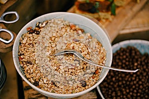 Close-up of a plate of oatmeal with dried fruit on a table with a breakfast cereal balls with cocoa.