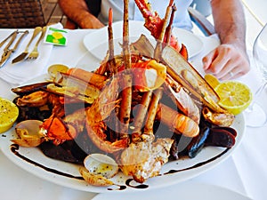 Close up of a plate with seafood and lobster. Traditional Mediterranean food.