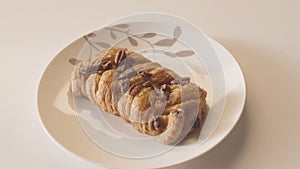 Close-up of plate of sweet pastries on white table. Stock footage. Beautiful and delicious pastries in coffee shop