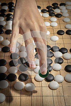 Close up of player hand with weiqi stone to make a move in Go game Weiqi, Baduk, Go ban - The  Ancient Traditional Asian